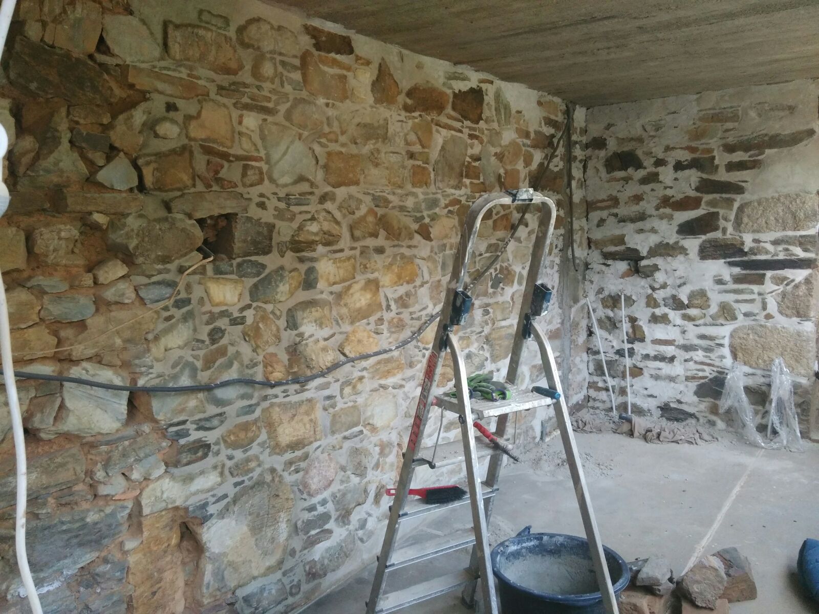 On March 3, 2018—two weeks before Marilisa, me and Jorrit would get to see the finished result—Laurelin made this photo. By this time, she had repointed most of wall between her pig sty and the adega, except for the left-most part. And you can see a chunk of wall, right of the corner, where she still had to brush off the excess mortar.